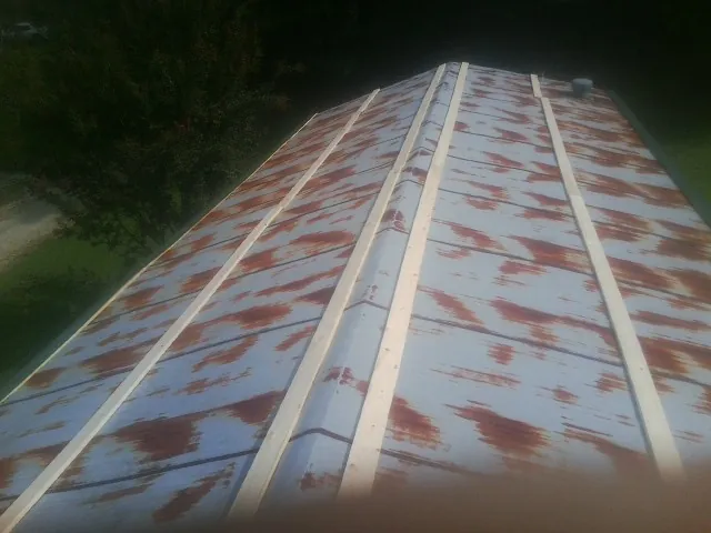 Rusted metal roof panels with new wood purlins before replacement — Storm Damage Roof Repair in Kaplan by Roofing Brothers